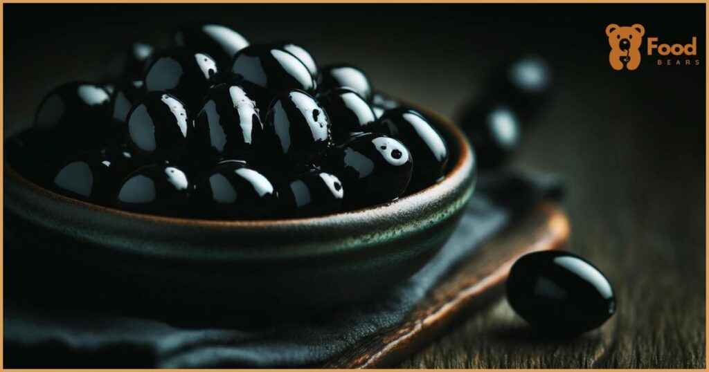 featuring a close-up of shiny black olives in a rustic ceramic bowl, beautifully arranged to highlight their glossy texture.